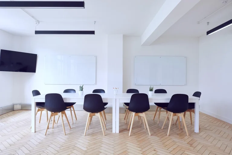 Bright and modern conference room with freshly painted white walls, sleek black chairs, and a large meeting table, professionally finished by commercial painters in Frankston.